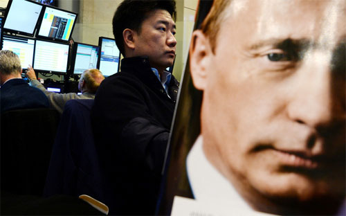 Ảnh Tổng thống Nga Vladimir Putin trên bìa một cuốn họa báo ở sàn giao dịch chứng khoán tại Moscow - Ảnh: Bloomberg.<br>