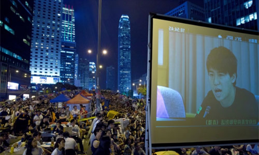 Người biểu tình Hồng Kông tập trung ở khu Mong Kok tối qua để theo dõi cuộc đàm phán được truyền hình trực tiếp - Ảnh: AP/WSJ.