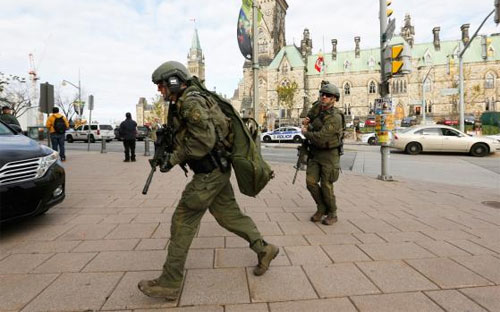 Binh sỹ thuộc lực lượng vũ trang Canada tiến vào khu vực xảy ra vụ tấn công bên ngoài tòa nhà Quốc hội ở Ottawa ngày 22/10 - Ảnh: Reuters.<br>