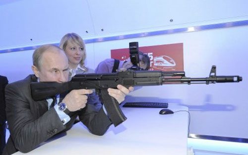 Tổng thống Nga Vladimir Putin ngắm một khẩu súng trường tại một trung tâm nghiên cứu ở Moscow hồi tháng 4/2012 - Ảnh: RIA Novosti/Reuters/BI.<br>