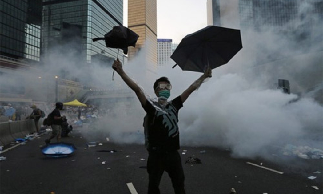 Một người biểu tình Hồng Kông giơ cao ô trên đường phố hôm 28/9 - Ảnh: Reuters.