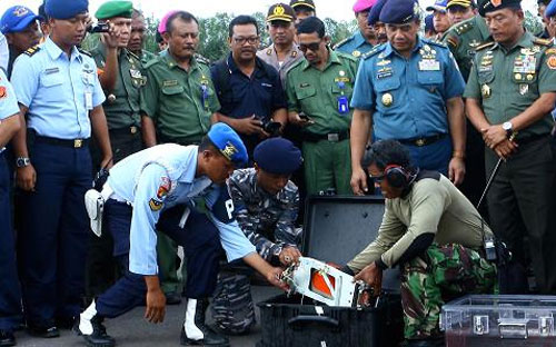 Các nhà tìm kiếm đưa một phần hộp đen máy bay AirAsia lên bờ ngày 12/1 - Ảnh: Getty/CNBC.<br>