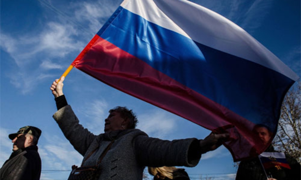 Người Crimea vẫy cờ Nga trong dịp một năm bán đảo này ly khai khỏi Ukraine và gia nhập Nga - Ảnh: Getty/Bloomberg.<br>