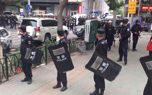 Cảnh sát đứng gác bên ngoài hiện trường vụ tấn công khủng bố ở Urumqi ngày 22/5 - Ảnh: AP.<br>