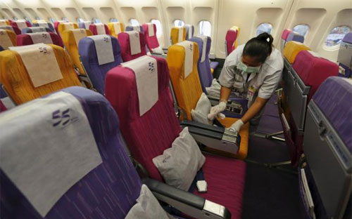 Nhân viên của hãng hàng không Thai Airways của Thái Lan đang dọn dẹp khoang hành khách trên một máy bay tại Sân bay Quốc tế Suvarnabhumi ngày 18/6/2015 - Ảnh: Reuters.<br>