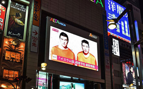 Hình ảnh hai con tin người Nhật trong tay IS trong một chương trình tin tức ở Nhật Bản ngày 20/1 - Ảnh: AP.<br>