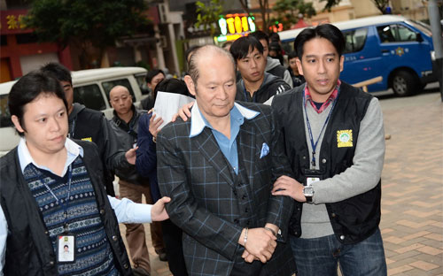 Alan Ho (giữa), người điều hành đường dây mại dâm lớn nhất Macau, bị cảnh sát bắt - Ảnh: AP.<br>