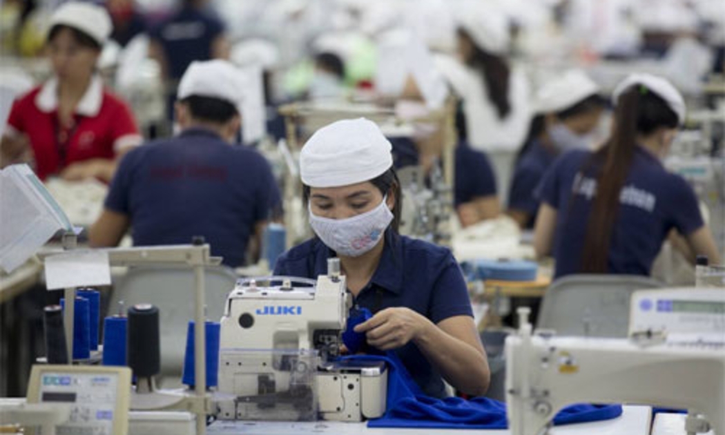 Công nhân làm việc trong nhà máy sản xuất hàng may mặc của công ty Esquel Group ở Thuận An, Bình Dương - Ảnh: Bloomberg.<br>