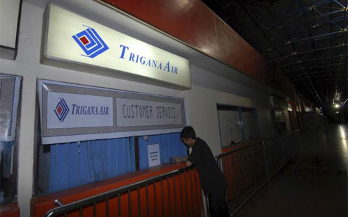 Một hành khách đứng trước quầy dịch vụ khách hàng của hãng Trigana Air ở Sân bay Sentani, tỉnh Papua của Indonesia ngày 16/8 - Ảnh: Reuters.<br>