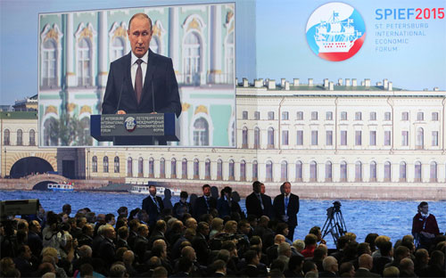 Hình ảnh Tổng thống Nga Vladimir Putin phát biểu phát trên một màn hình lớn tại Diễn đàn Kinh tế Thế giới St. Petersburg, Nga - Ảnh: Bloomberg.<br>