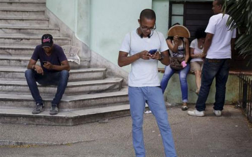 Người dân Cuba truy cập mạng từ một điểm phát wi-fi công cộng ở Havana hôm 2/7 - Ảnh: Reuters.<br>