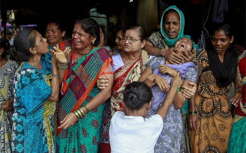 Thân nhân một người thiệt mạng vì rượu giả ở Mumbai ngày 21/6 - Ảnh: Reuters.<br>