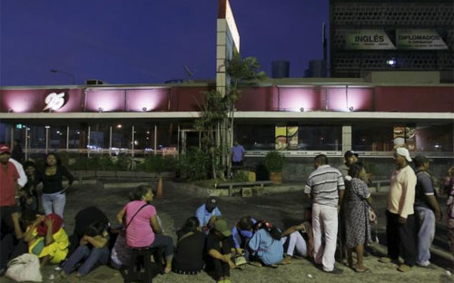 Người dân Venezuela xếp hàng xuyên đêm trước cửa siêu thị để chờ mua thực phẩm - Ảnh: Reuters.<br>