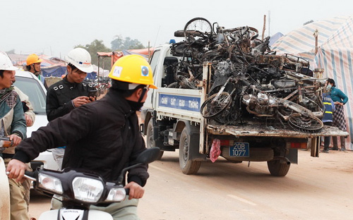 Hàng chục xe máy cháy rụi được ôtô của lực lượng cảnh sát giao thông chở đi khỏi hiện trường - Ảnh: Tuổi Trẻ.<br>
