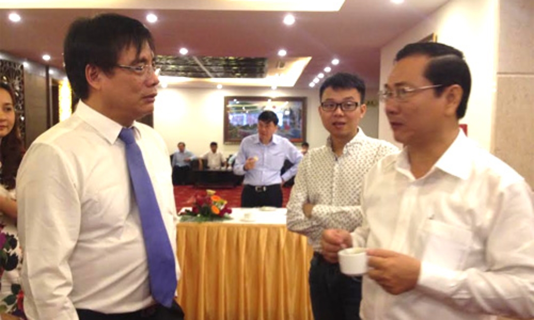 Viện trưởng Viện Kinh tế Việt Nam Trần Đình Thiên (bên trái) trao đổi bên lề Diễn đàn Kinh tế Mùa xuân 2015.