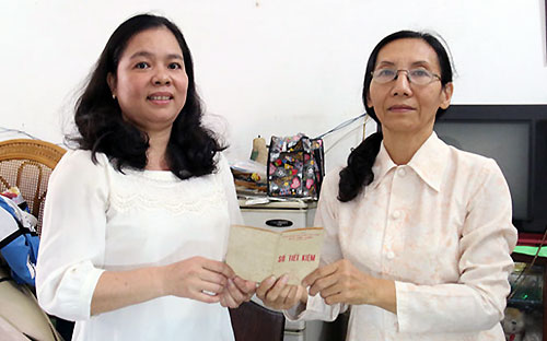 Bà Lê Thị Bích Thủy (bên phải) hiến tặng sổ tiết kiệm cho đại diện Bảo tàng Tp.HCM - Ảnh: Tuổi Trẻ.<br>