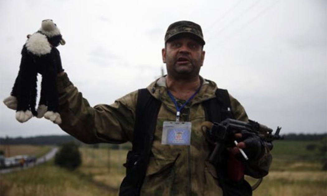 Một dân quân thân Nga đứng ở hiện trường vụ máy bay MH17 rơi ở Đông Ukraine - Ảnh: Reuters.