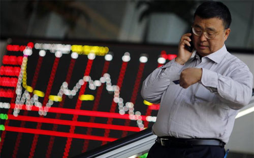 Một nhà đầu tư trên sàn chứng khoán Thượng Hải - Ảnh: Reuters.<br>