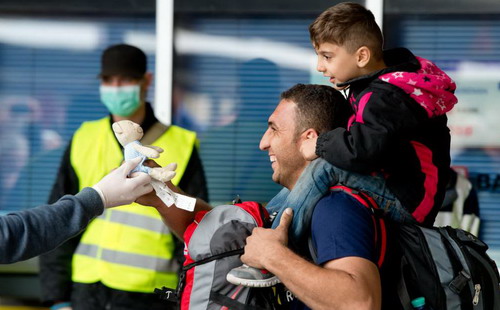 Người nhập cư được tặng cả đồ chơi khi đến nhà ga thành phố Munich, Đức - Ảnh: Time.