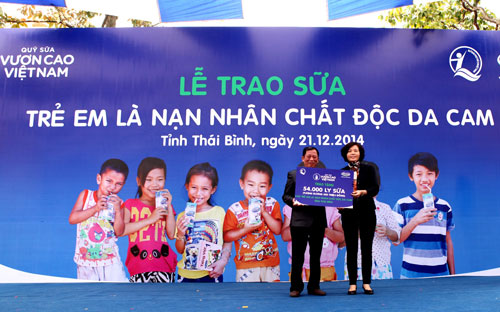 Bà Bùi Thị Hương - Giám đốc Điều hành Vinamilk trao bảng sữa tượng trưng 54.000 ly sữa tương đương 500 triệu đồng của quỹ sữa "Vươn cao Việt Nam" cho trẻ em là nạn nhân chất đôc da cam tỉnh Thái Bình.