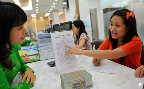 Đã hơn một năm qua, lãi suất huy động VND đã rút về khá sâu, phổ biến 
dưới 8%/năm, trong khi tỷ trọng lãi suất từ 13-15% vẫn còn đáng kể. 
Nhưng tỷ lệ lãi biên như phản ánh lại co hẹp, hẳn một phần 
lớn do chi phí hoạt động đội lên - Ảnh: Tuổi Trẻ.<br>