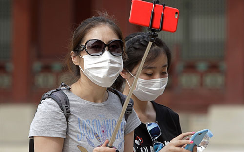 Đến nay, WHO chưa khuyến nghị giảm đi lại tới Hàn Quốc, nhưng hàng nghìn du khách quốc tế đã hủy chuyến đi tới nước này - Ảnh: Getty/Bloomberg.<br>