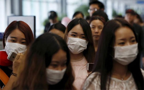 Hành khách đeo khẩu trang để tránh lây nhiễm MERS tại Sân bay Quốc tế Incheon, Hàn Quốc - Ảnh: Reuters.<br>
