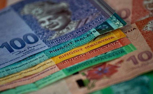 Đồng ringgit chịu tác động mạnh từ việc giá hàng hóa giảm sâu và căng thẳng chính trị liên quan đến Thủ tướng Najib Razak xung quanh những cáo buộc về biển thủ công quỹ - Ảnh: Reuters.