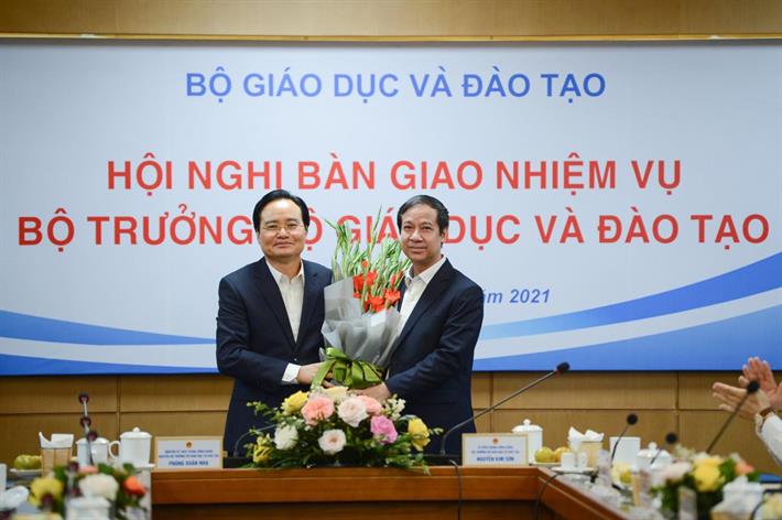 Tân Bộ trưởng Bộ Giáo dục và Đào tạo Nguyễn Kim Sơn tặng hoa người tiền nhiệm Phùng Xuân Nhạ - Ảnh: Bộ Giáo dục và Đào tạo
