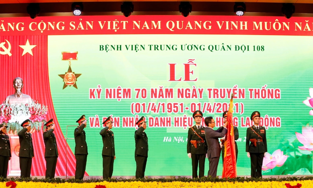 Phó Thủ tướng Vũ Đức Đam gắn Danh hiệu Anh hùng Lao động thời kỳ đổi mới lên lá cờ truyền thống của Bệnh viện Trung ương Quân đội 108.