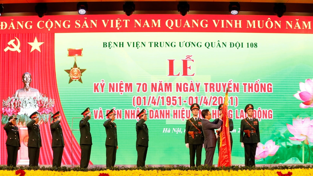 Phó Thủ tướng Vũ Đức Đam gắn Danh hiệu Anh hùng Lao động thời kỳ đổi mới lên lá cờ truyền thống của Bệnh viện Trung ương Quân đội 108.