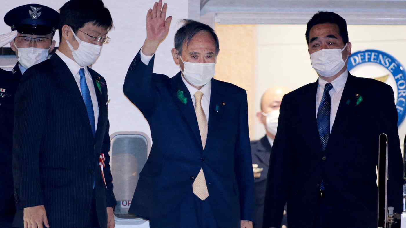 Thủ tướng Nhật Yoshihide Suga vẫy tay chào khi rời sân bay Haneda (Tokyo) bay tới Washington để gặp Tổng thống Mỹ Joe Biden - Ảnh: Nikkei Asia
