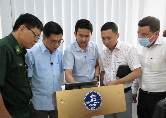 Ông Nguyễn Văn Dũng (thứ hai, từ trái sang) cùng các đại biểu trải nghiệm hệ thống định danh khách hàng điện tử tại UBND Quận 1.
