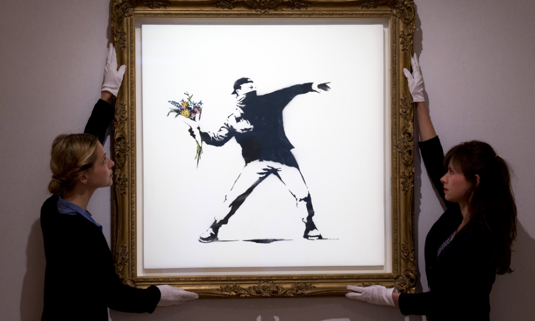 Tác phẩm “Love is in the Air” của họa sĩ đường phố Banksy - Ảnh: Getty Images