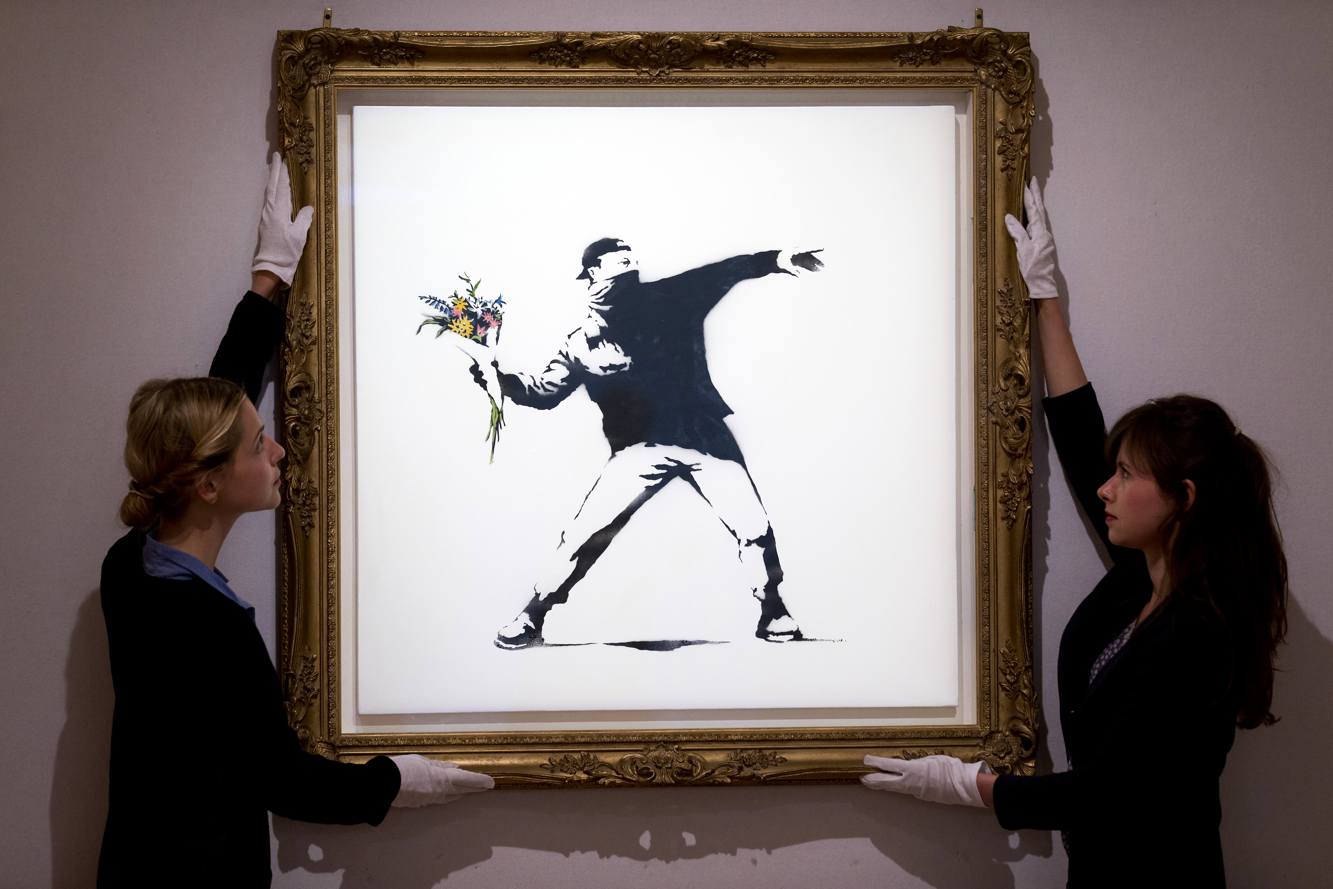 Tác phẩm “Love is in the Air” của họa sĩ đường phố Banksy - Ảnh: Getty Images
