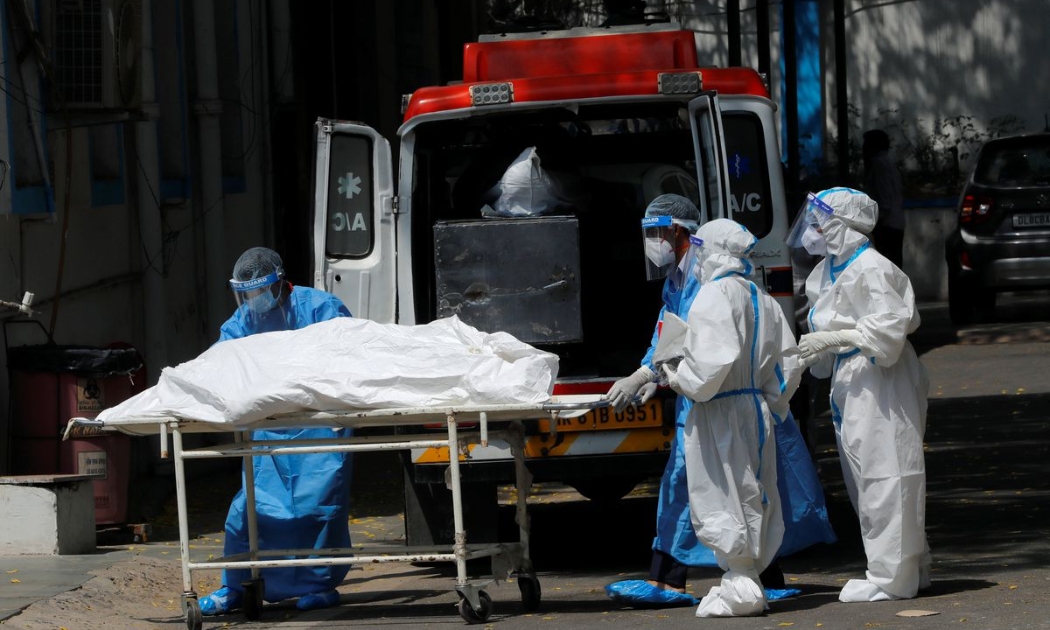 Nhân viên tang lễ di chuyển thi thể một bệnh nhân Covid tử vong ở New Delhi, Ấn Độ, ngày 5/5 - Ảnh: Reuters.