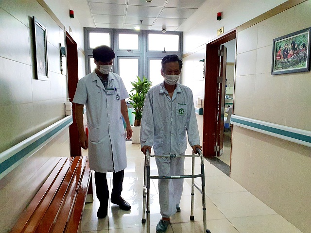 Sau hơn 1 năm chỉ c&oacute; thể ngủ ngồi v&agrave; di chuyển nhờ xe lăn, hiện B&aacute;c Vọng đ&atilde; c&oacute; thể tự đi trong khung h&igrave;nh chữ U.