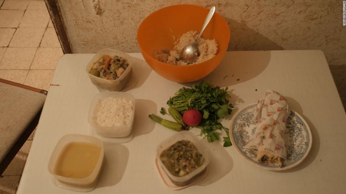 Bữa tối với một bát cơm, một ít súp đậu lăng xin từ hàng xóm, một chiếc bánh mì nướng ăn dở từ hôm trước và một chút rau mà Khadija dốc sạch tiền để mua - Ảnh: CNN
