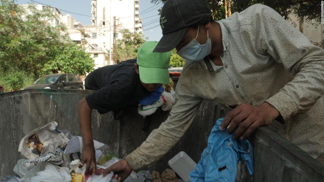 Ahmad lục thùng rác để tìm kiếm thức ăn - Ảnh: CNN