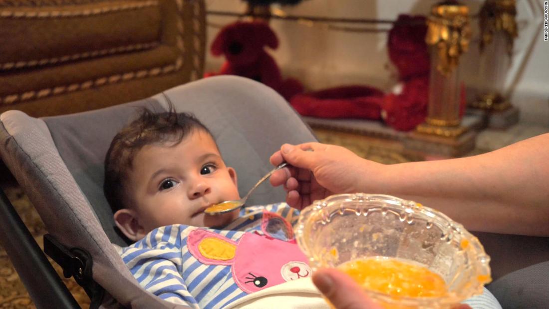 Khadija cho con ăn nước bí xanh xay nhuyễn cùng cà rốt và khoai tây thay bột - Ảnh: CNN