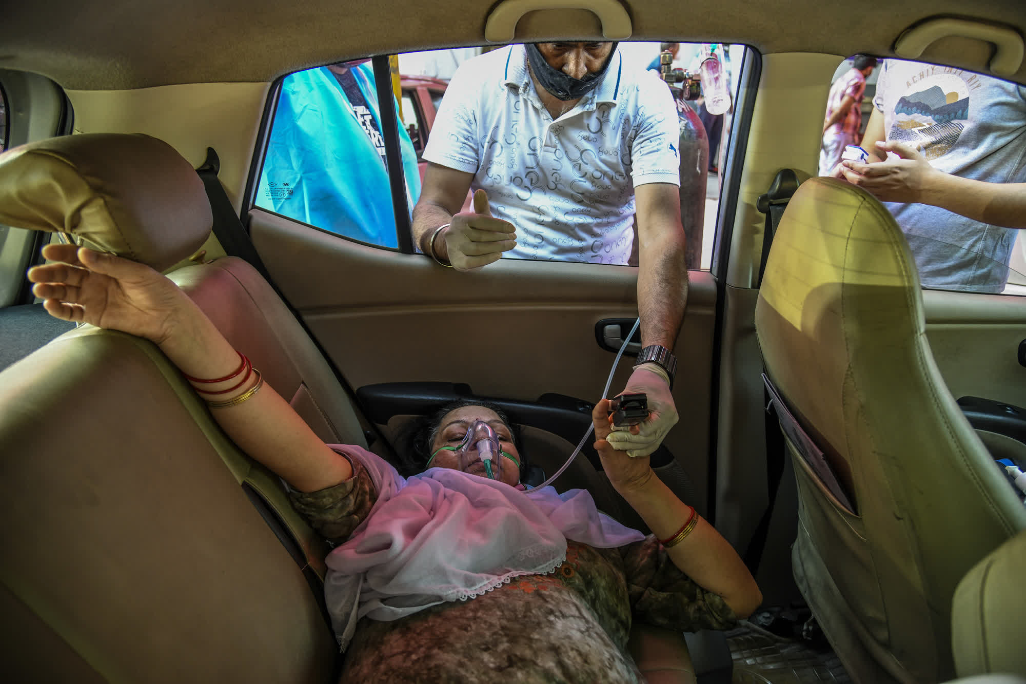 Ấn Độ đang trải qua đợt b&ugrave;ng ph&aacute;t dịch bệnh tồi tệ nhất thế giới với số ca nhiễm mới l&ecirc;n tới 400.000 người v&agrave; gần 4.000 ca tử vong mỗi ng&agrave;y. Nhiều chuy&ecirc;n gia v&agrave; bệnh nh&acirc;n cho biết c&aacute;c th&agrave;nh phố bị ảnh hưởng nặng nề nhất của Ấn Độ hiện giống như v&ugrave;ng chiến sự. C&aacute;c bệnh viện đang phải vật lộn với t&igrave;nh trạng qu&aacute; tải, cạn kiệt vật tư y tế v&agrave; nhiều bệnh nh&acirc;n kh&ocirc;ng được cứu do thiếu oxy. Trong ảnh l&agrave; một bệnh nh&acirc;n Covid-19 được thở oxy trong một chiếc &ocirc; t&ocirc; đang đỗ b&ecirc;n ngo&agrave;i bệnh viện để chờ giường bệnh tại New Delhi ng&agrave;y 25/4 - Ảnh:&nbsp;The New York Times