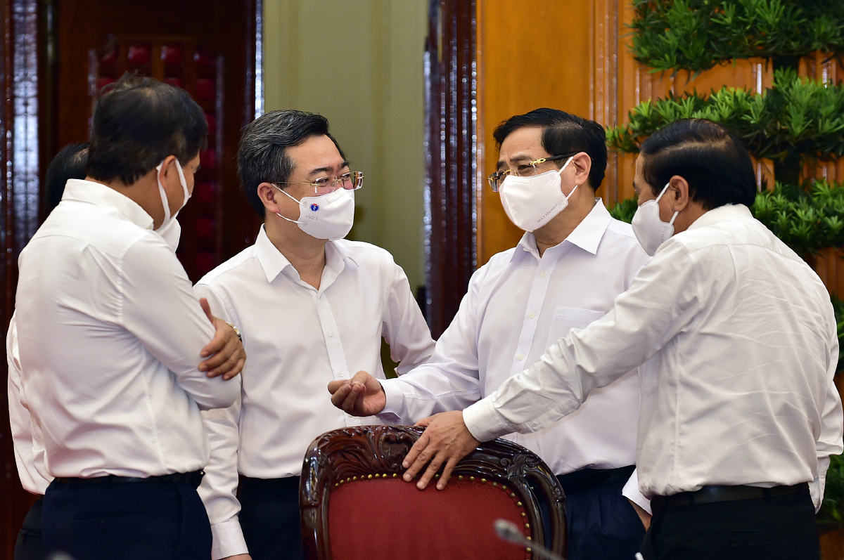 Thủ tướng Phạm Minh Chính trao đổi với Phó Thủ tướng Lê Văn Thành, Bộ trưởng Bộ Xây dựng Nguyễn Thanh Nghị và các đại biểu dự cuộc làm việc - Ảnh: VGP.