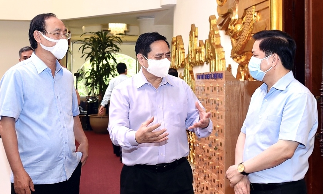 Thủ tướng Phạm Minh Chính trao đổi với lãnh đạo Bộ Giao thông vận tải bên lề cuộc họp - Ảnh: VGP.