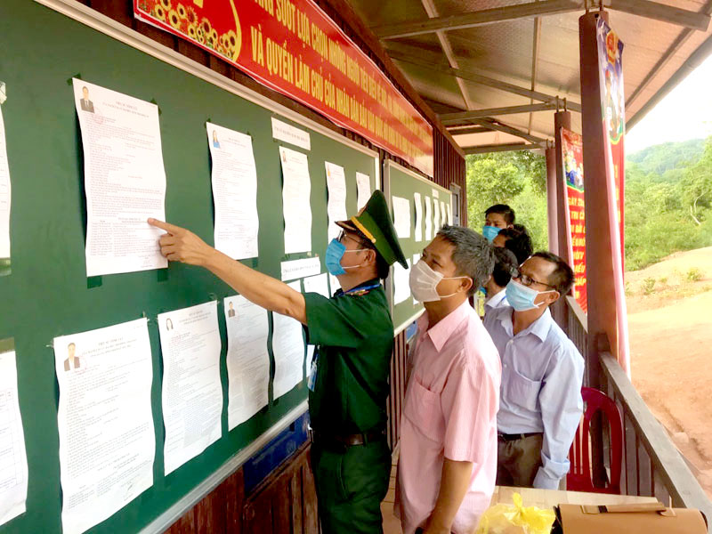 Bộ đội bi&ecirc;n ph&ograve;ng v&agrave; b&agrave; con ở x&atilde; Thượng Trạch, huyện Bố Trạch, Quảng B&igrave;nh t&igrave;m hiểu c&aacute;c ứng cử vi&ecirc;n trước khi ghi phiếu bầu - Ảnh:&nbsp; CTV.