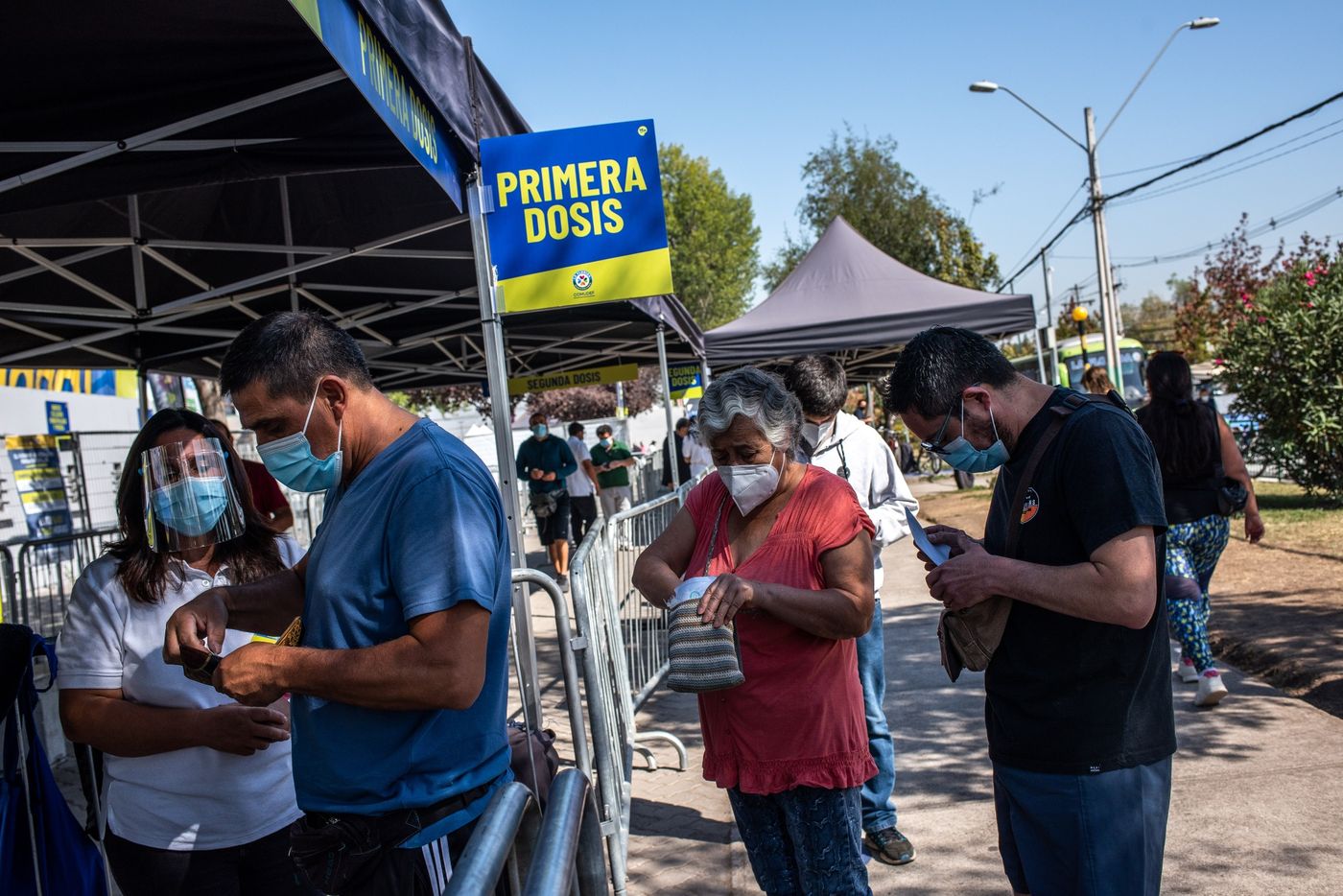 Người d&acirc;n xếp h&agrave;ng b&ecirc;n ngo&agrave;i một trung t&acirc;m ti&ecirc;m chủng tạm thời tại S&acirc;n vận động Bicentenario ở Santiago, Chile ng&agrave;y 29/3 - Ảnh: Bloomberg