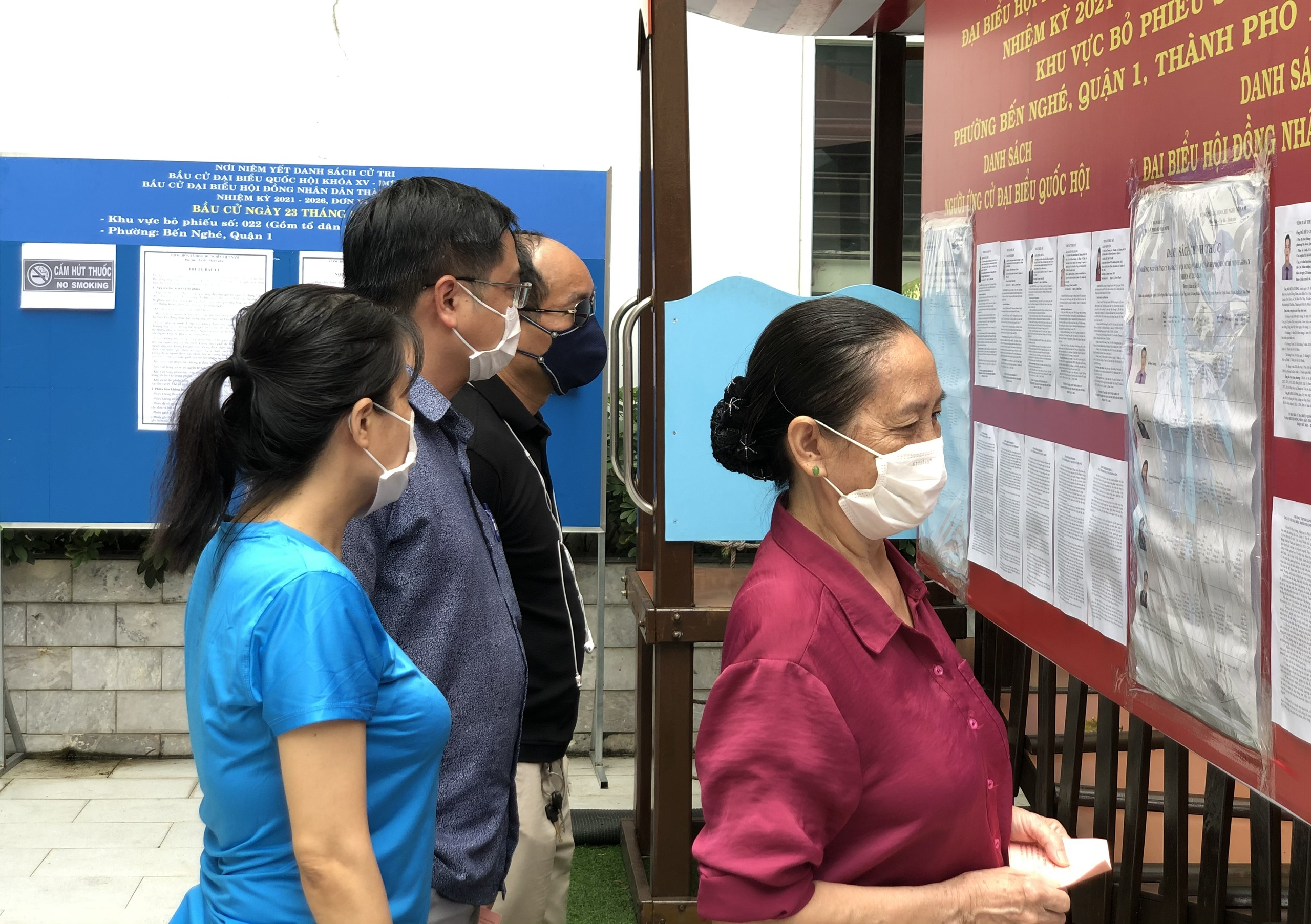 Các cử tri tổ 38, phường Bến Nghé, Quận 1 đang xem danh sách đại biểu được niêm yết để chọn lựa.