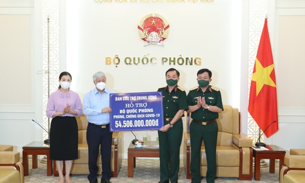 Chủ tịch Ủy ban nhân dân MTTQ Việt Nam Đỗ Văn Chiến trao số tiền hỗ trợ cho Thượng tướng Hoàng Xuân Chiến, Thứ trưởng Bộ Quốc phòng. Ảnh - Quang Vinh.