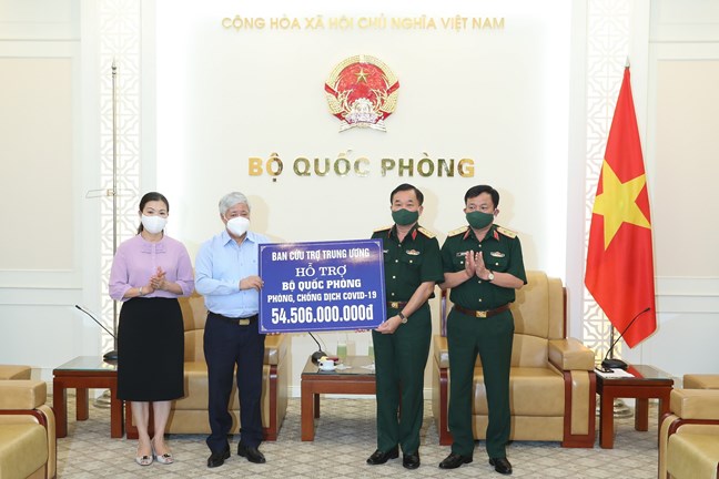 Chủ tịch Ủy ban nhân dân MTTQ Việt Nam Đỗ Văn Chiến trao số tiền hỗ trợ cho Thượng tướng Hoàng Xuân Chiến, Thứ trưởng Bộ Quốc phòng. Ảnh - Quang Vinh. 