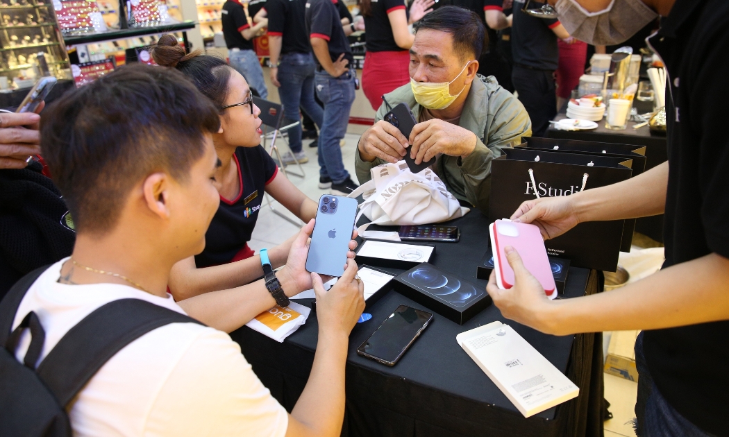 Nhiều khách hàng trẻ thích thú chiếc iPhone 12 pro trên tay tại FPT Shop