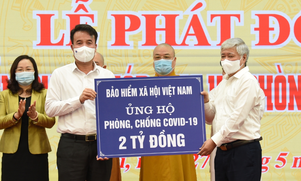 Tổng Giám đốc Bảo hiểm xã hội Việt Nam Nguyễn Thế Mạnh (trái) trao tiền ủng hộ tới Chủ tịch Ủy ban Trung ương Mặt trận Tổ quốc Việt Nam Đỗ Văn Chiến. Ảnh - MTTQ Việt Nam.